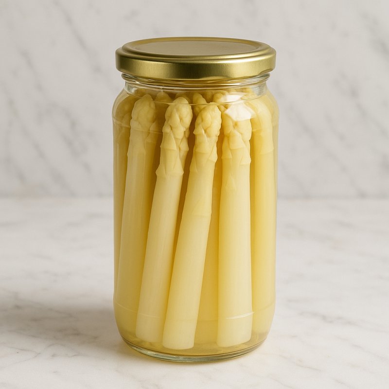 Ein Glas mit hellem Spargelfond neben frischen Spargelstangen